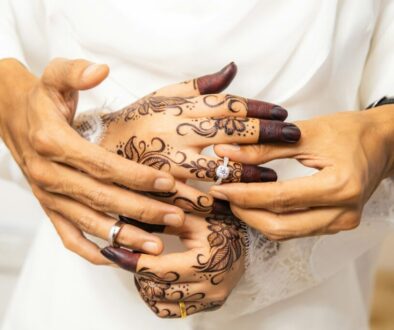 Hands with henna exchanging wedding rings, symbolising questions to ask before marriage in Islam